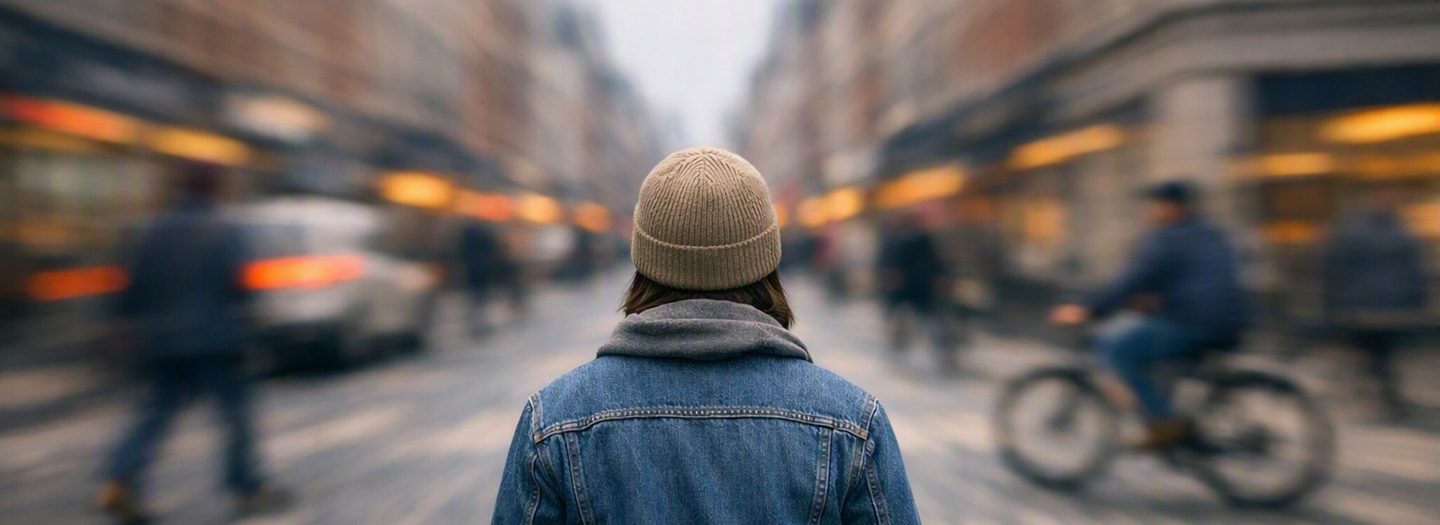 A man standing still as a city street blurs around him